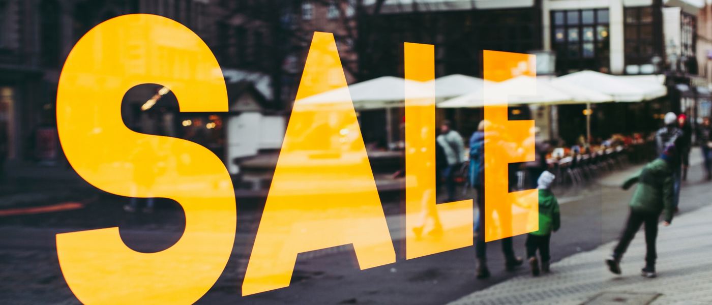 Yellow SALE sign in a storefront window, promoting an estate sale to Quad Cities shoppers Yellow SALE sign in a storefront window, promoting an estate sale to Quad Cities shoppers